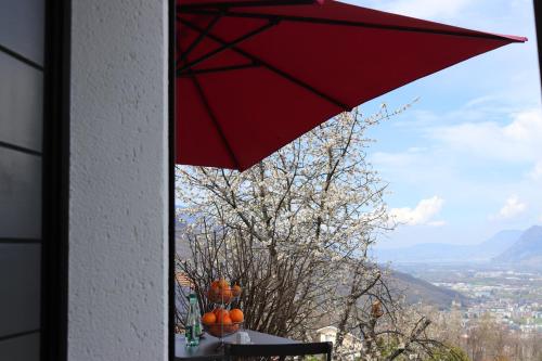 a red umbrella sitting on top of a table with pumpkins at la lapia in Monthey