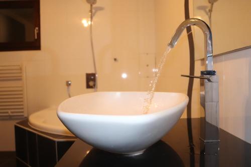a bathroom with a sink with water coming out of it at la lapia in Monthey
