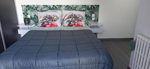 - un lit avec une couette bleue et 2 oreillers dans l'établissement Chambre d'hôtes, au Mans