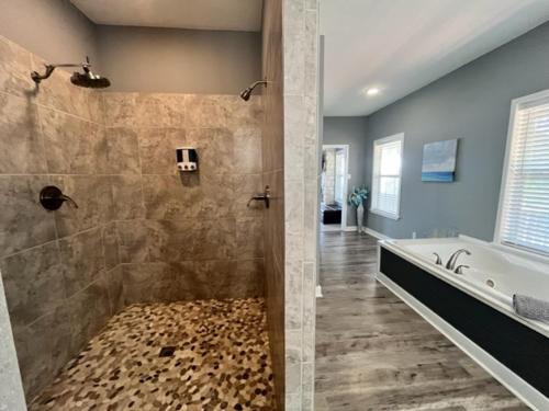 een badkamer met een douche, een bad en een wastafel bij Fortner Pointe At Cedar Creek in Gun Barrel City