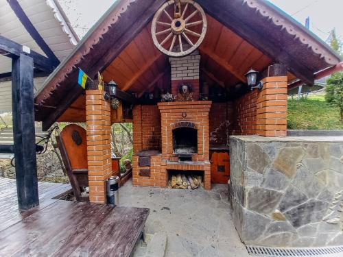 a brick fireplace in the back of a house at Котедж в Карпатах in Huklyvyy