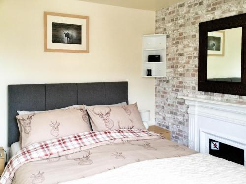 a bedroom with a bed and a fireplace at April Cottage in Gordon