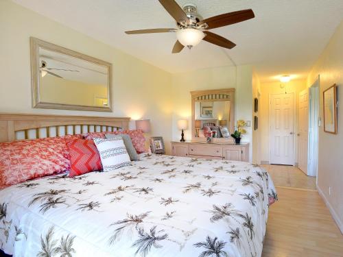 Un dormitorio con una cama y un ventilador de techo. en Nani Kai Hale 303, en Kihei