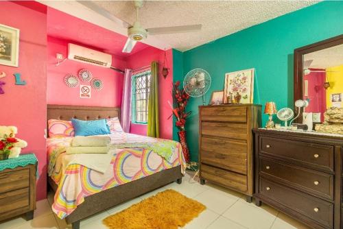 Dormitorio colorido con cama y lavamanos en Colorful Private Room Oasis, en Montego Bay