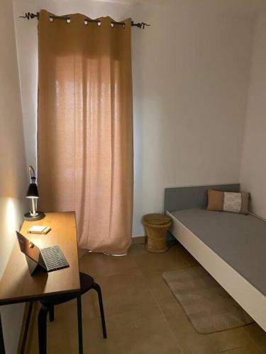une chambre avec un lit et une table avec un ordinateur portable dans l'établissement Akropole de Caroline, Central, Lumineux, Calme, Free Parking, Lift, 3 Beds, à Draguignan