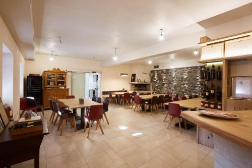 een restaurant met tafels en stoelen en wijnflessen bij Ferjančič estate rooms in Ajdovščina