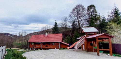 drewniany domek z czerwonym dachem i schodami w obiekcie Котедж в Карпатах w mieście Huklyvyy