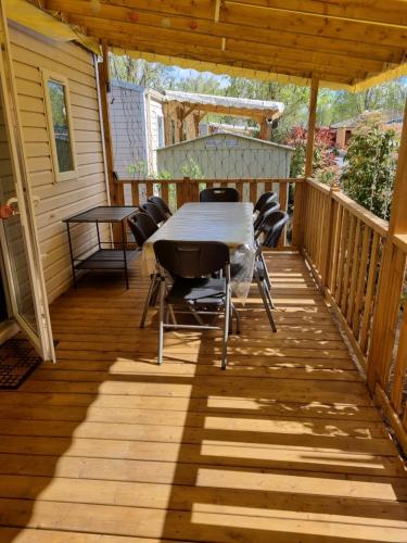 a wooden deck with a table and chairs on it at Mobil Home Camping Elysée Vagues Océanes in Le Grau-du-Roi