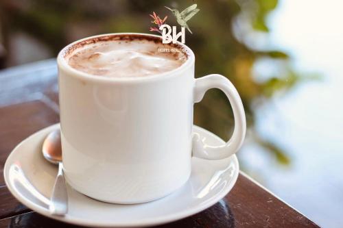 a cup of coffee on a plate on a table at Bunde Haus Hotel EXPRESS BOUTIQUE in Ibagué