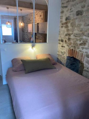 - un grand lit dans une chambre dotée d'un mur en pierre dans l'établissement Appartement centre ville Quimper avec terrasse, à Quimper
