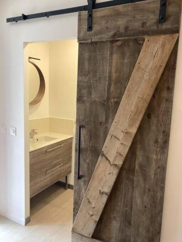 - une porte coulissante dans la salle de bains pourvue d'un lavabo dans l'établissement Appartement centre ville Quimper avec terrasse, à Quimper