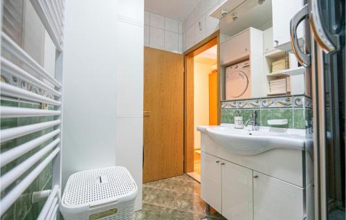 een badkamer met een wastafel en een spiegel bij Cozy Home In Vrgorac With Outdoor Swimming Pool in Vrgorac