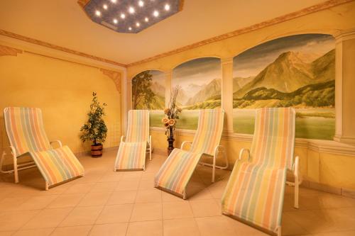 a room with three chairs and a painting on the wall at Pension Glockenstuhl in Finkenberg