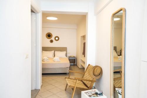 ein Schlafzimmer mit einem Bett, einem Stuhl und einem Spiegel in der Unterkunft MYKONOS HOUSE Wanderlust , Mykonos Town in Mykonos Stadt