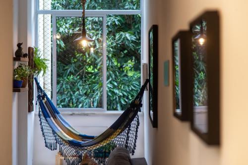 a hammock in a room with a window at Vista Verde Laranjeiras in Rio de Janeiro
