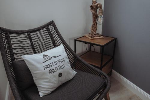 a wicker chair with a pillow on it next to a table at Deine MEERZeit in Büsum