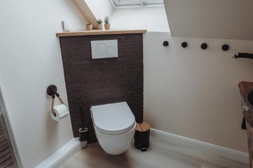 a bathroom with a toilet and a brick wall at Deine MEERZeit in Büsum