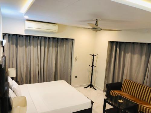 a bedroom with a bed and a ceiling fan at Star House in Islamabad