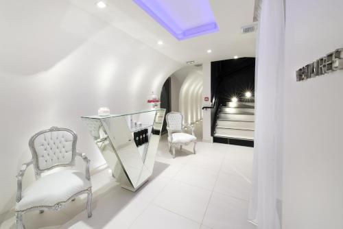 a white salon with two chairs and a mirror at Vertigo Hotel, Dijon, a Member of Design Hotels in Dijon