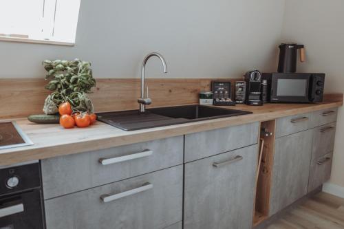 a kitchen with a sink and a counter with fruits and vegetables at Deine MEERZeit in Büsum