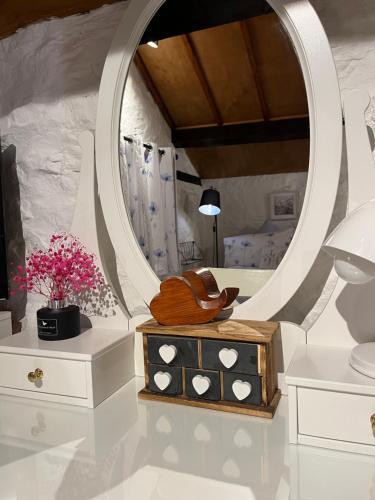 a bathroom with a mirror and a wooden purse on a dresser at Old Nursery in Coity