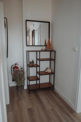 a shelf in a room with a mirror on the wall at Deine MEERZeit in Büsum
