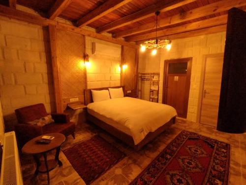 阿瓦諾斯的住宿－Begam Butik Otel，一间卧室配有一张床、一张沙发和一把椅子