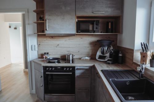 a kitchen with a stove and a sink in it at Deine MEERZeit in Büsum
