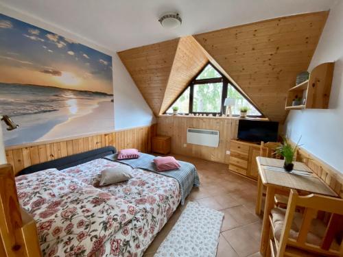 a bedroom with a bed and a desk and a television at Apartamenty Marea Rentals przy Promenadzie Słońca Poddąbie in Poddąbie