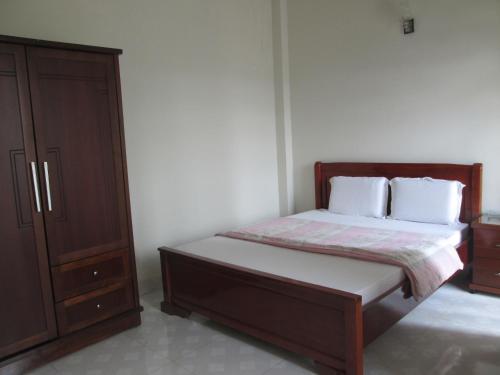 a bedroom with a bed and a dresser at Ngoc Phuong Hotel in Bảo Lộc