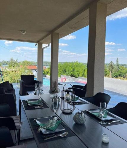 a dining table with plates and glasses on a patio at Vila Sunset Jugovo in Udovice