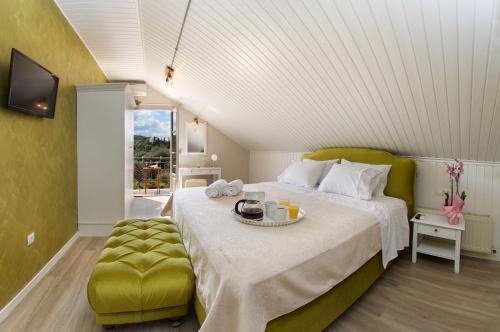 a bedroom with a large bed and a green ottoman at Magnolia Apartments in Fiskardho