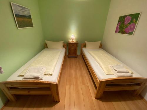 Habitación con 2 camas individuales y suelo de madera. en Gasthaus Goa, en Ernsthausen