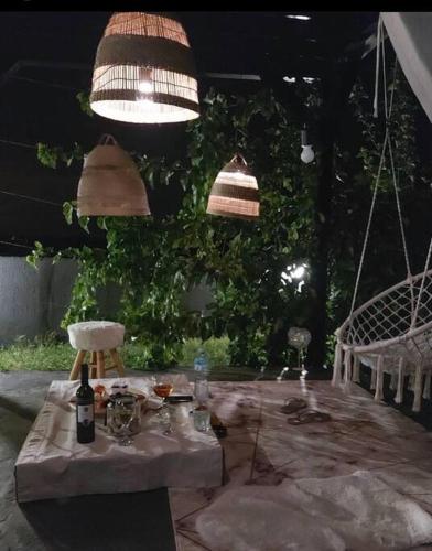 a table with a bottle of wine and two hanging lights at Vila Sunset Jugovo in Udovice