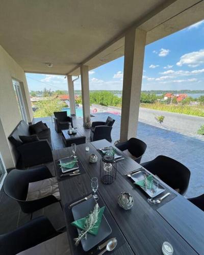 a dining room with a table and chairs with a view at Vila Sunset Jugovo in Udovice