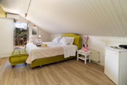 a bedroom with a large bed and a green chair at Magnolia Apartments in Fiskardho