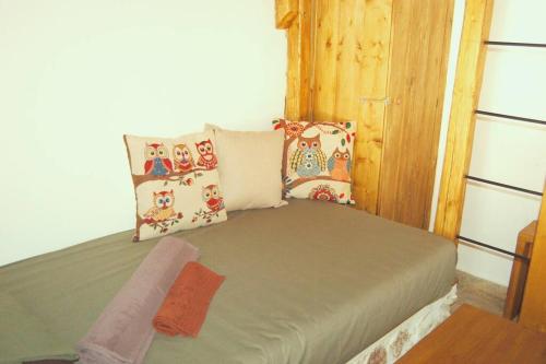 Cama pequeña en habitación con almohadas en Άνεσις διαμέρισμα στην Πάρο en Aliki