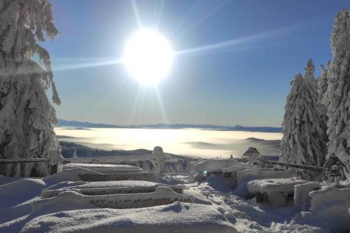 a snow covered mountain with the sun in the sky at Beskidzka Stodoła przy szlaku z pięknym widokiem in Złatna