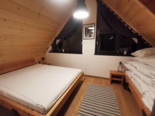 - une chambre avec 2 lits dans une cabane en bois dans l'établissement Beskidzka Stodoła przy szlaku z pięknym widokiem, à Złatna