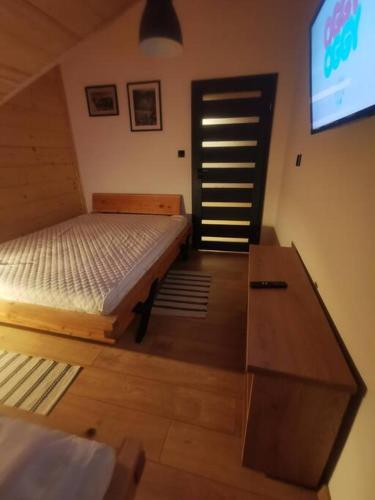 a bedroom with a bed and a dresser and a tv at Beskidzka Stodoła przy szlaku z pięknym widokiem in Złatna