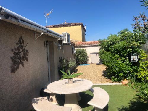 a patio with a table and chairs in a yard at Studio refait à neuf avec jardin Aigues Mortes in Aigues-Mortes