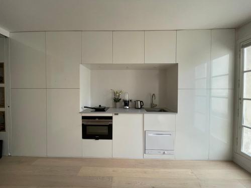 a kitchen with white cabinets and a stove at Superbe studio avec balcon, situé entre 6è et 7è ! in Paris