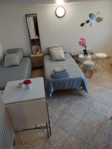 - un salon avec deux lits et une table dans l'établissement Studio meublé avec piscine partagée, à La Ferté-Gaucher
