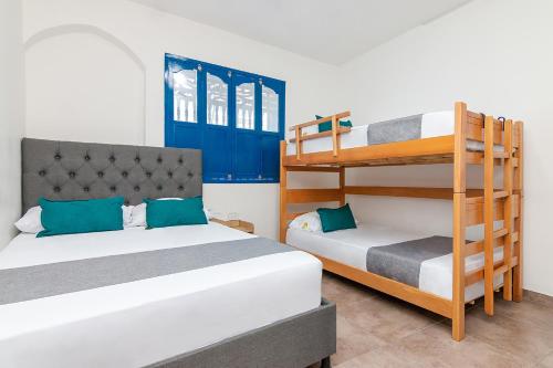 a bedroom with two beds and a bunk bed at Casa Flor Hostel & Drinks in Ríohacha