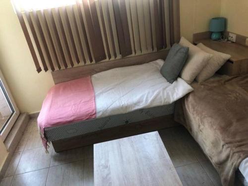 een klein bed in een kamer met een radiator bij Cute Studio Apt, Pollo Resort in Sunny Beach