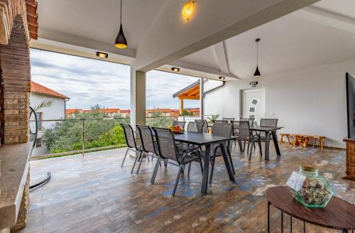 a dining room with tables and chairs and a large window at Villa Asta Medulin in Medulin