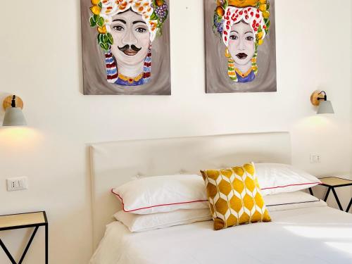 - une chambre avec 3 peintures murales au-dessus d'un lit dans l'établissement Villa di Nera Apartments, à Palerme