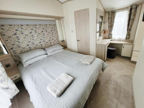 a bedroom with a large bed with two towels on it at Meadow Lodge in South Cerney