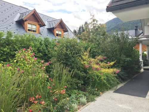a garden in front of a house with flowers at Apartmaji Kranjska Gora in Kranjska Gora