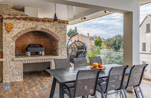 a patio with a table and a brick fireplace at Villa Asta Medulin in Medulin